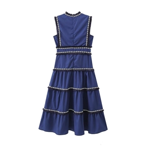 Détails de robe à volants bleu marine avec broderies et finitions à franges