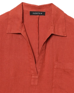 Dettaglio camicia in lino rosso ruggine con scollo a V profondo e taschino applicato