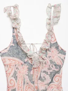 Dettaglio dello scollo a V con volant e stampa paisley arancione su chiffon blu