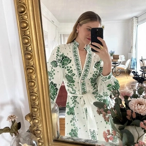 Weißes Sommerkleid mit grünem Blumendruck, V-Ausschnitt, Puffärmeln und Taillenband
