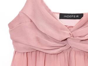 Macro shot of pink midi dress with twisted pleated neckline and brand label detail