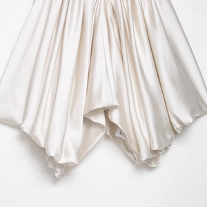Detailed macro shot of champagne satin fabric with elegant pleats and silky texture