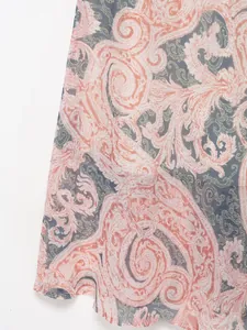 Dettaglio ravvicinato del tessuto in chiffon paisley rosa corallo con eleganti motivi floreali