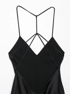 Detail of cross back straps and satin texture on black backless midi dress
