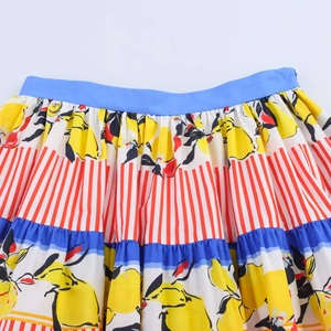 Detail of layered lemon print skirt with vibrant blue waistband and striped patterns
