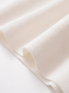 Close-up of premium white ribbed knit fabric showing fine texture and soft elasticity