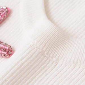White ribbed knit sweater for women featuring delicate pink beaded floral neck detail