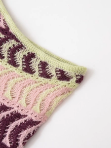 Detail of colorful jacquard knit fabric with light green ribbed edges and fine texture