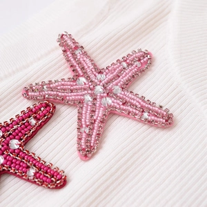 Starfish shaped beaded patch with rhinestones on a minimalist ribbed knit fabric