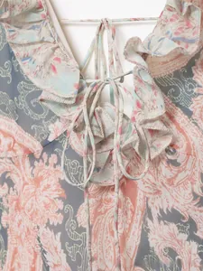 Dettaglio vestito floreale con volant, scollo a V profondo e delicato cordoncino sottile