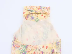 Detailed top-down view of yellow floral print camisole with twist knot neck detail