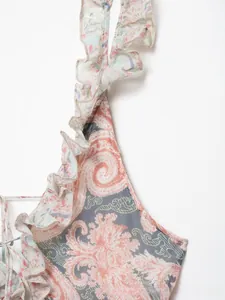 Dettaglio della stampa paisley rosa e blu con delicate ruches sullo scollo del vestito