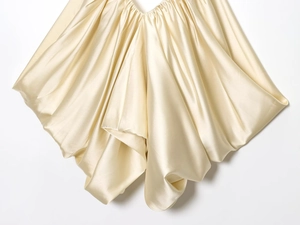 Detailed view of champagne satin fabric showing elegant pleated texture and silky shine