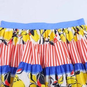 Close-up of lemon print skirt showing blue waistband and red white striped patterns
