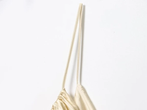 Detail of champagne satin top featuring delicate thin straps and ruched neckline texture
