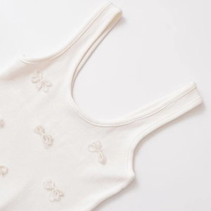 White ribbed knit tank top featuring handcrafted 3D pearl bow decorations and U-neckline