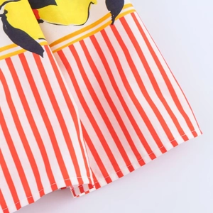 Close-up of lemon print hem with red white vertical stripes on woven fabric