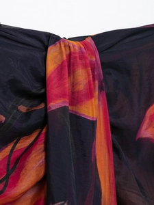 Dettaglio ravvicinato di tessuto chiffon con fiori astratti arancioni e rosa vivaci