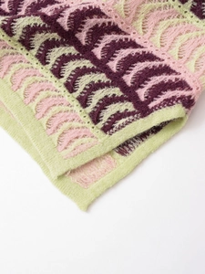 Detailed close-up of wavy knit texture and scalloped hem in purple, pink and green