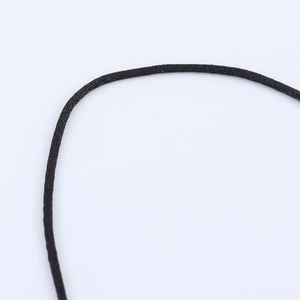 Macro detail showing the texture of a black braided rope for necklace and jewelry making