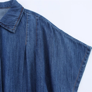 Detail of dark blue denim dress featuring orange contrast stitching and classic lapel