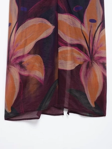 Dettaglio del tessuto in chiffon semitrasparente con stampe di gigli arancioni vivaci