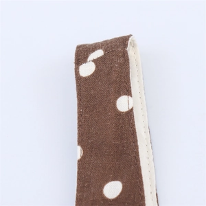 Macro shot of brown polka dot midi dress showing fabric texture and neat edge stitching
