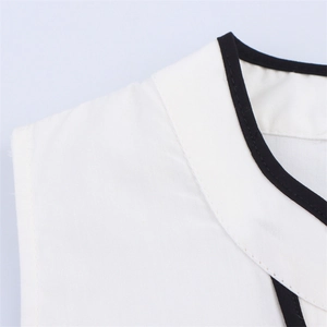 Detailed close-up of white shirt collar with black piping and fine stitching texture