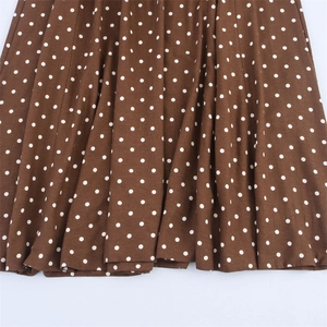 Close-up of the dark brown fabric with white polka dots and delicate textile texture