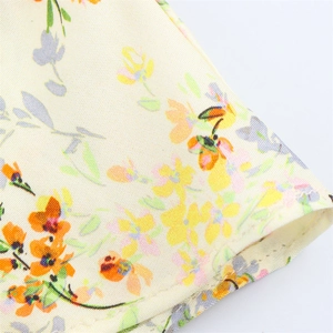 Gros plan du tissu en satin floral avec détails de couture sur robe imprimée beige