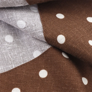 Close-up of brown polka dot midi dress fabric showing linen texture and stitching