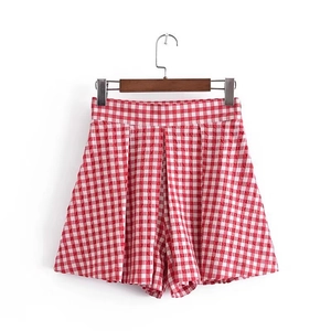 Detail of red gingham high-waisted shorts featuring pleats and a relaxed A-line cut