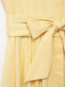 Close-up of light yellow shirt dress featuring a tied bow belt and twill texture detail