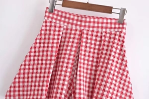 Detail of red and white checkered high-waist seersucker skirt with pleated texture