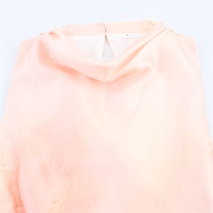 Detail view of smooth orange satin midi dress featuring a draped neckline and size S label