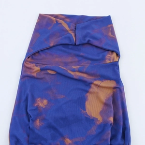 Détail d'une robe en tulle avec imprimé tie-dye bleu et orange et col découpé unique