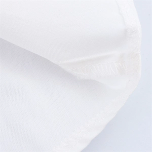 Close-up of high-quality overlock stitching and flat seam on white polka dot dress fabric
