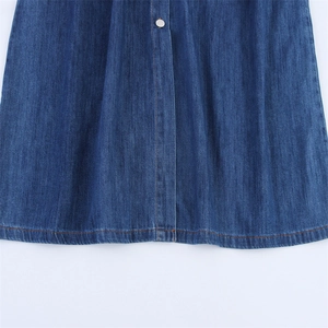Close-up of dark blue denim dress with metal button and orange contrast stitching detail