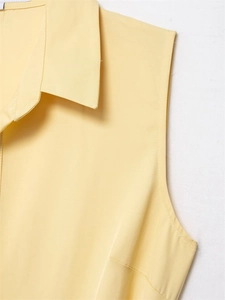Detail view of high-quality light yellow sleeveless shirt collar with neat stitching