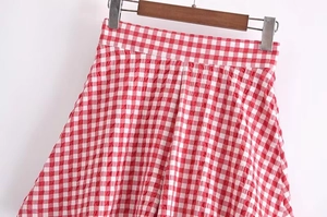 Detailed close-up of the red and white gingham fabric with pleated texture on the shorts