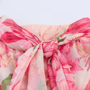 Detail eines geblümten Chiffonkleides mit Faltenstruktur und elegantem Schleifenknoten