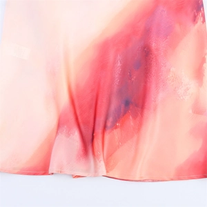 Detailed close-up of vibrant tie-dye silk satin fabric with high-quality hem stitching