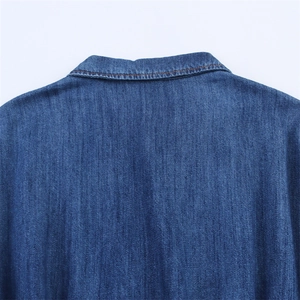 Detail of dark blue denim dress collar featuring contrast orange stitching craftsmanship