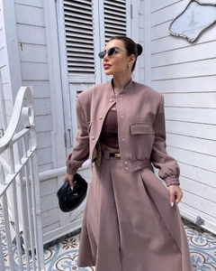 Detail of pink bomber jacket with cargo pockets and matching pleated midi skirt outfit