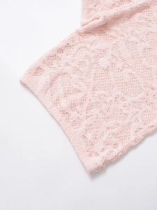 Detailansicht aus weichem rosa Plüschstrick mit 3D-Rautenmuster und Textur