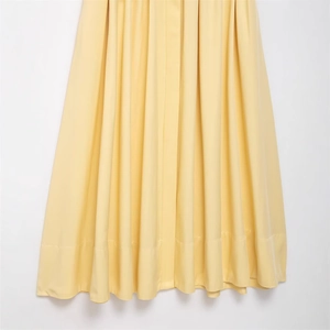 Elegant bright yellow pleated shirt dress with fine accordion folds and stitched hemline