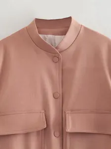 Detail view of pink bomber jacket with large pockets and matching fabric buttons
