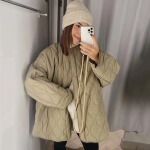 Detail der khakifarbenen Steppjacke mit Zwiebelmuster und lockerer Oversize-Passform