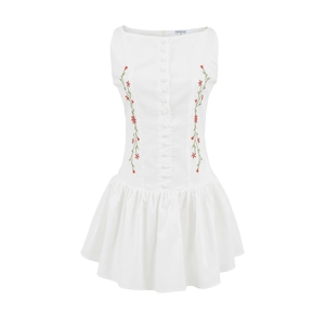 Detail view of floral embroidery and cloth-covered buttons on a white cotton dress