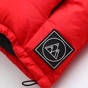 Detailaufnahme der roten Steppjacke mit verstellbarem Kordelzug und Logo-Patch